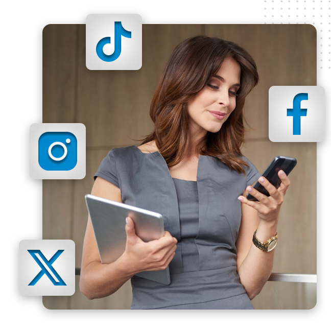 A woman in a gray dress holds a tablet and looks at her smartphone, surrounded by social media icons—perfectly illustrating the importance of strong brand identity and effective branding solutions in today’s digital landscape.