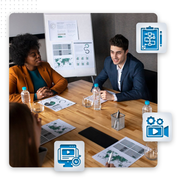 Video Strategy img Four people sit around a conference table with charts and documents, discussing business. A flipchart with graphs and video production process icons is in the background, highlighting their focus on modern tech and media strategies.
