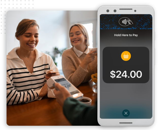 xtreme-automator-pos-integration-img Two women smile at a table as one pays with her smartphone using contactless payment; a mobile screen in the foreground displays a $24.00 purchase—effortless transactions powered by automation company innovations.